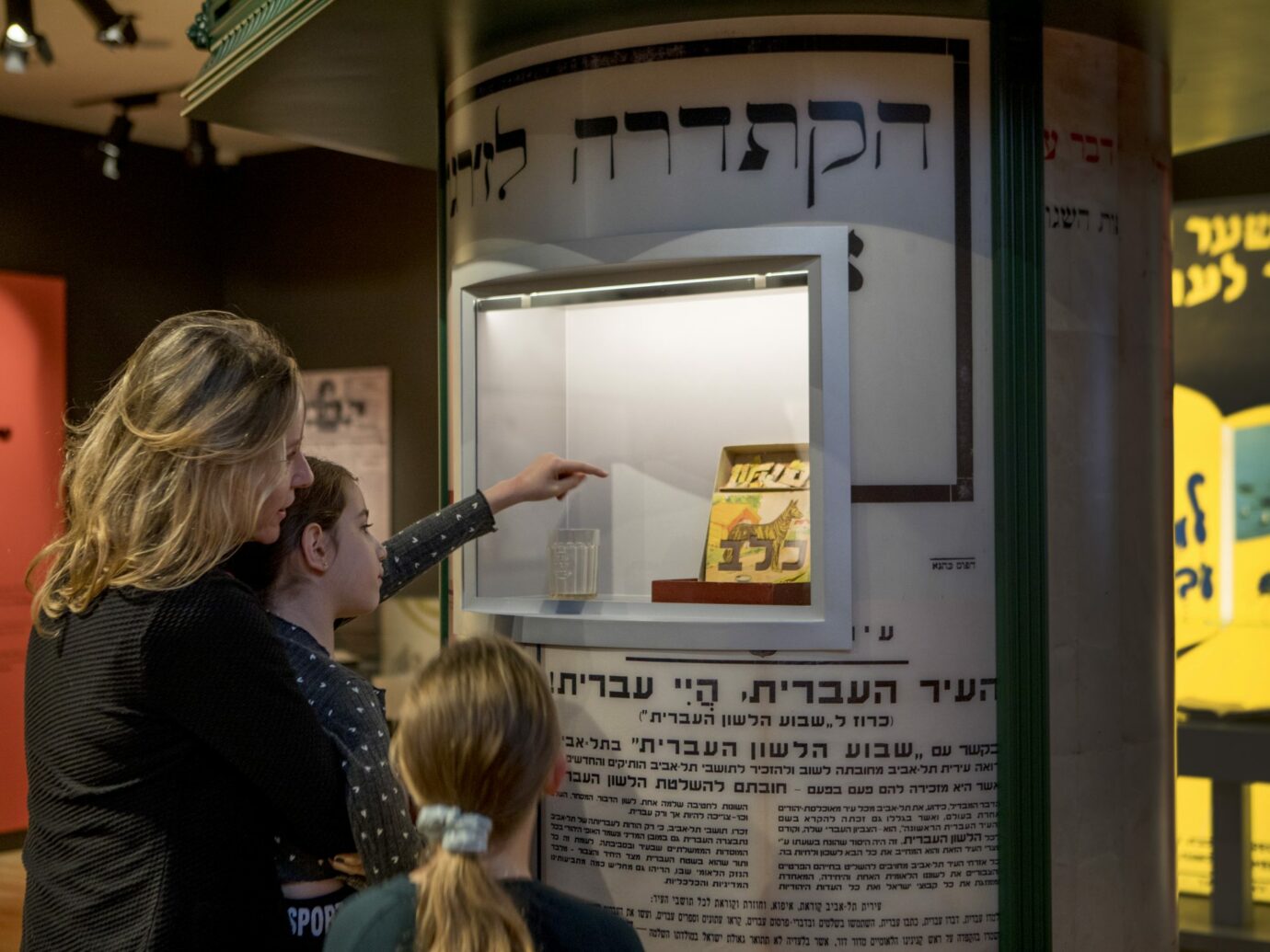 Visitors pointing at a historic artifact case